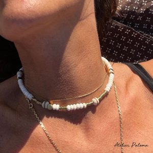 Collier ras de cou écru et doré.